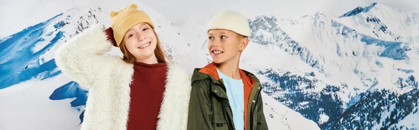 Kleiner Junge mit Blick auf süßes Mädchen, beide im Winter stilvolle Outfits glücklich lächelnd, Mode, Banner — Stockfoto