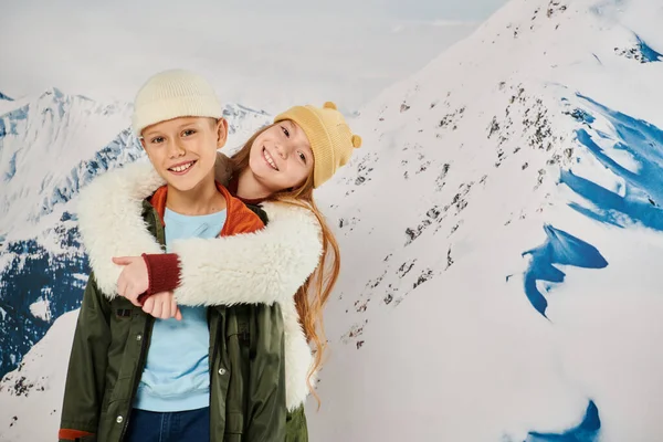 Веселые друзья в стильной зимней одежде обнимающие друг друга с горным фоном, концепция моды — стоковое фото