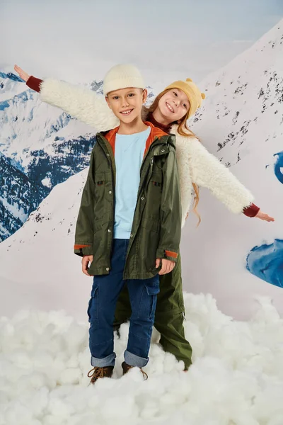 Vertikale Aufnahme von kleinen netten Freunden in Winterkleidung, die zusammen posieren und Spaß haben, Mode — Stockfoto