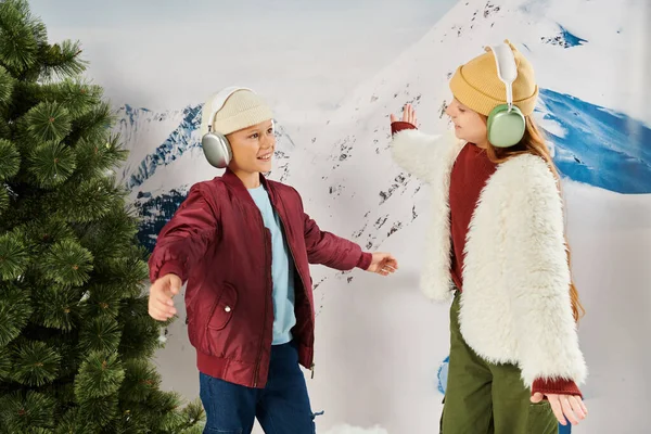Mignonne preteen fille et garçon en hiver vêtements souriant à l'autre avec montagne sur fond, de la mode — Photo de stock