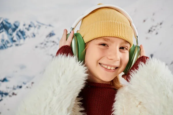 Portrait of joyous little girl touching her headset and smiling joyfully at camera, fashion concept — Stock Photo