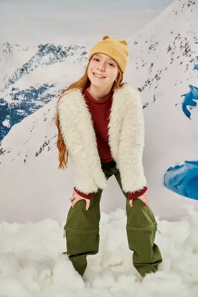 Вертикальный снимок маленькой стильной девушки в модном зимнем наряде весело улыбаясь в камеру, мода — стоковое фото