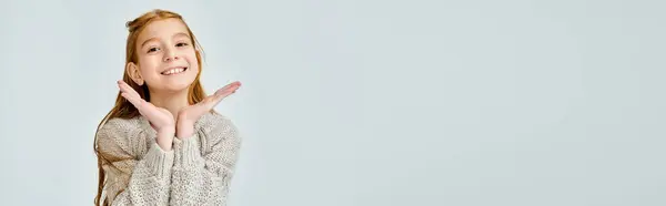 Pretty little girl in casual sweater looking at camera, hands under face, fashion concept, banner — Stock Photo