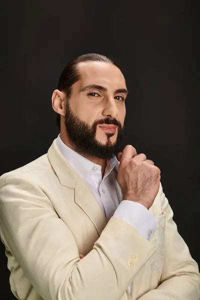 Elegant and bearded arabic man in white shirt and blazer looking at camera on black background — Stock Photo