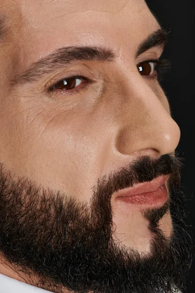 Крупним планом портрет впевненого арабського чоловіка з карі очі позує і дивиться на чорний фон — стокове фото