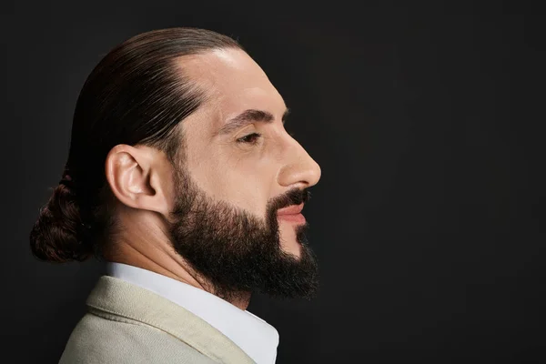 Side view, portrait of bearded and confident arabic man in white shirt posing on black backdrop — Stock Photo