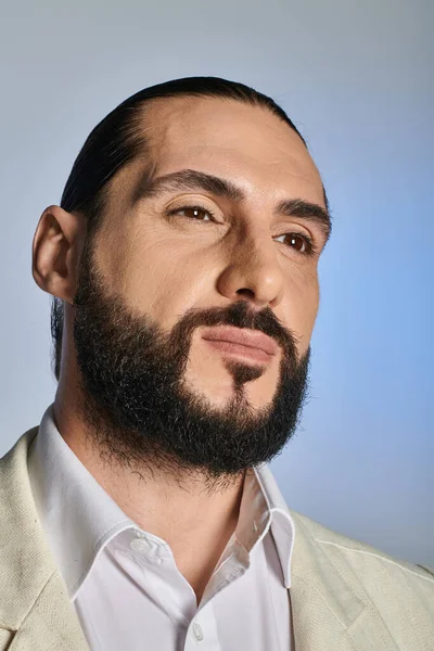 Portrait of handsome and bearded arabic man in white elegant attire on grey background, confident — Stock Photo