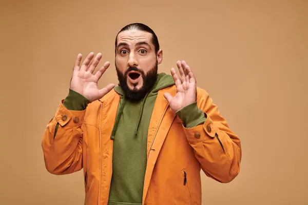 Schockierter Mann aus dem Nahen Osten mit Bart und offenem Mund gestikuliert auf beigem Hintergrund, wow — Stockfoto