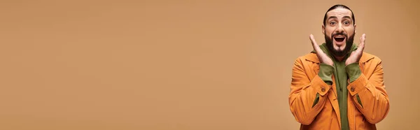 Homme moyen-oriental étonné avec barbe et bouche ouverte gestuelle sur fond beige, bannière wow — Photo de stock