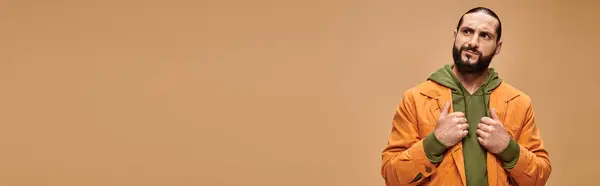 Pensivo homem do Oriente Médio com barba de pé em traje casual em pano de fundo bege, banner — Fotografia de Stock