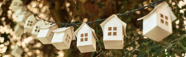 Banner of eco-friendly garland made of wooden houses on green tree inside of greenhouse — Stock Photo