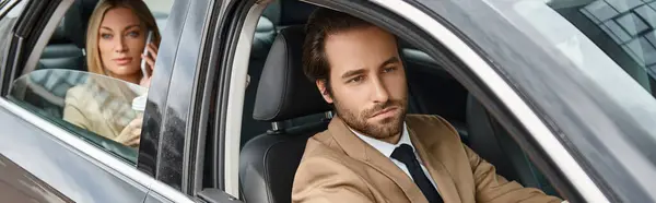 Hombre barbudo con estilo de conducción de coches cerca de atractiva mujer de negocios rubia hablando en el teléfono inteligente, bandera - foto de stock