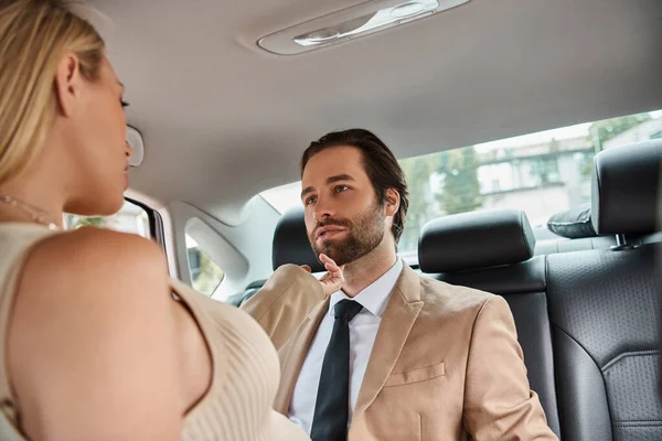 Passionate blonde businesswoman seducing  bearded elegant business partner while traveling in car — Stock Photo