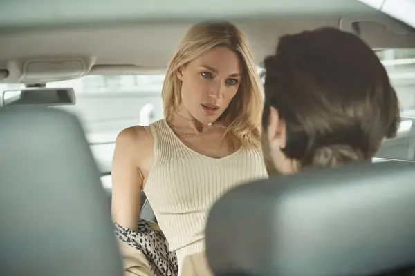 Hot blonde businesswoman seducing colleague while traveling in luxury car, love affair at work — Stock Photo