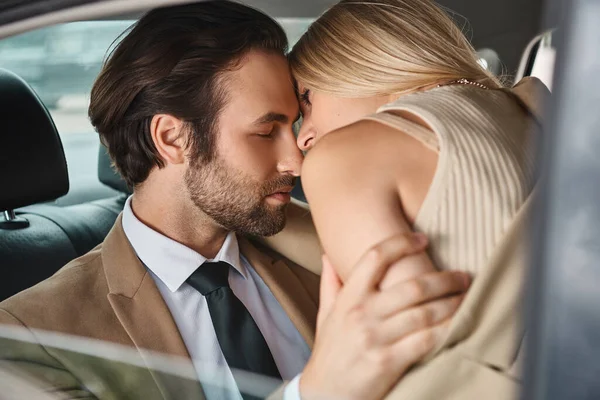 Coppia d'affari appassionata ed elegante in abbigliamento formale abbracciare mentre si viaggia in auto, romanticismo — Foto stock