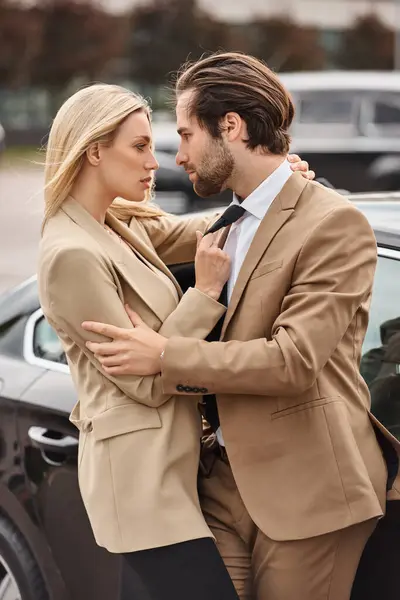 Couple attrayant et passionné dans l'usure formelle embrasser et regarder l'autre près de la voiture — Photo de stock