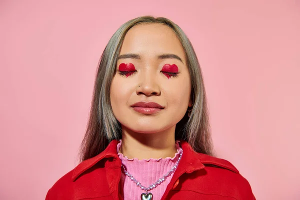 Retrato de jovem mulher asiática com coração em forma de maquiagem olho e cabelo tingido posando com olhos fechados — Fotografia de Stock