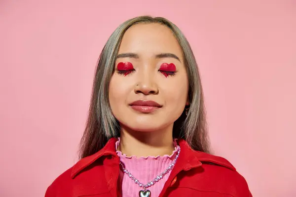 Portrait of young asian woman with heart shaped eye makeup and dyed hair posing with closed eyes — Stock Photo