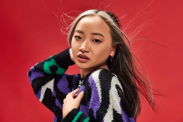 Wind weht im Gesicht der verführerischen jungen asiatischen Frau mit gefärbten Haaren im Pullover mit Animal Print — Stockfoto