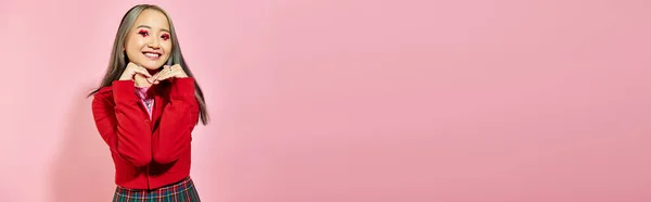 Valentinstag Banner, glückliche asiatische Frau mit Herz Augen Make-up zeigt Herz mit Händen auf rosa — Stockfoto