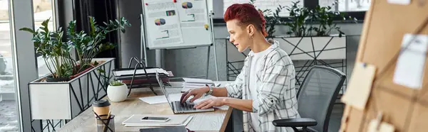 Queer personne en tenue décontractée tapant sur ordinateur portable tout en étant assis sur le lieu de travail au bureau, bannière — Photo de stock