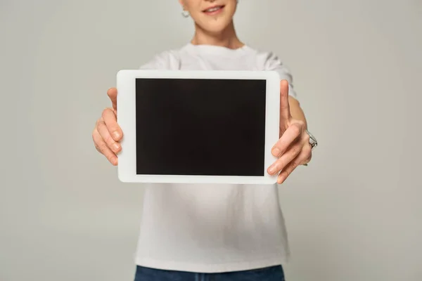 Cropped view of queer person in white t-shirt showing digital tablet with blank screen on grey — Stock Photo
