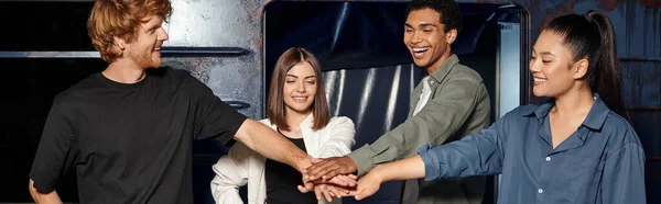 Young multicultural group of friends stacking hands while having quest in escape room, banner — Stock Photo