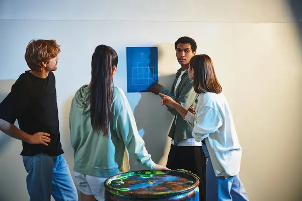 African american man finding clue near interracial friends during quest in escape room, mystery — Stock Photo