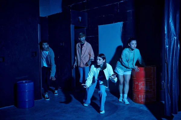 Group of multicultural young people engaged in thrilling escape room challenge, indoor adventure — Stock Photo