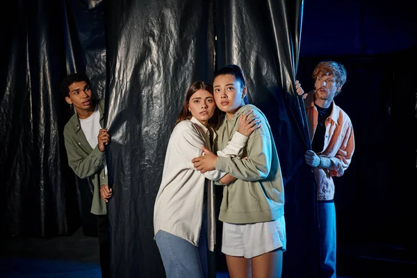 Scared multicultural young people engaged in thrilling escape room challenge, indoor adventure — Stock Photo