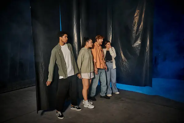 Grupo de quatro assustado interracial amigos de pé dentro de escape quarto durante quest — Fotografia de Stock