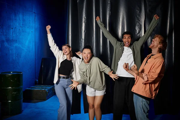 Group of young multicultural friends celebrating success after solving mystery in escape room — Stock Photo