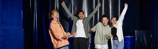 Gruppe von vier multikulturellen Freunden feiert Erfolg bei Escape-Room-Challenge, jubelt Banner — Stockfoto