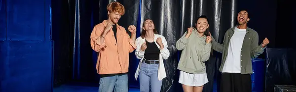 Group of four interracial friends celebrating success in an escape room challenge, rejoice banner — Stock Photo