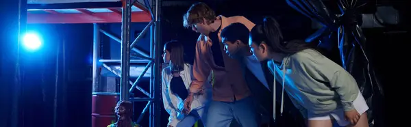 Banner of diverse and curious young people looking at scary mannequin during a quest room challenge — Stock Photo