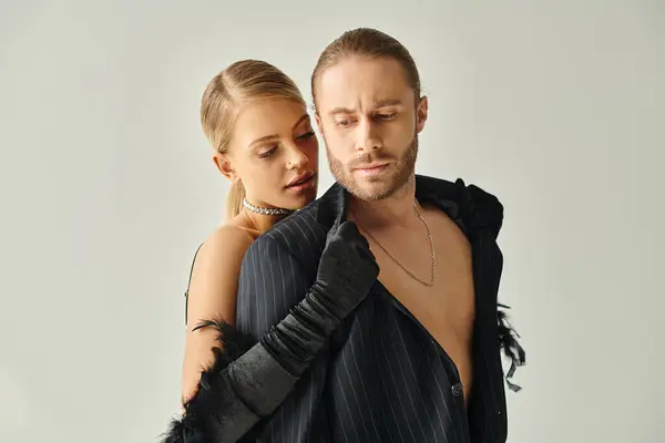 Appealing blonde woman in elegant dress with collected hair hugging warmly her boyfriend, couple — Stock Photo