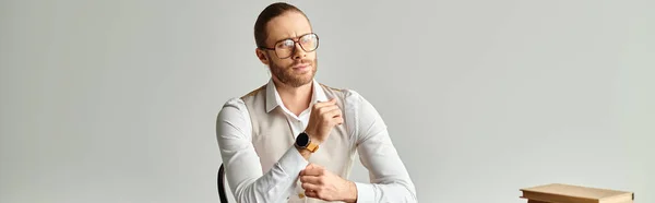 Bell'uomo concentrato con barba e occhiali seduto a tavola mentre lavora sodo in ufficio, striscione — Foto stock