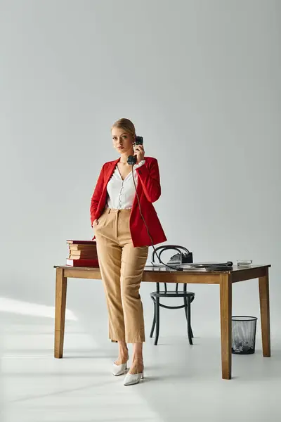 Attractive young woman in vibrant attire posing with hand in pocket while talking by retro phone — Stock Photo