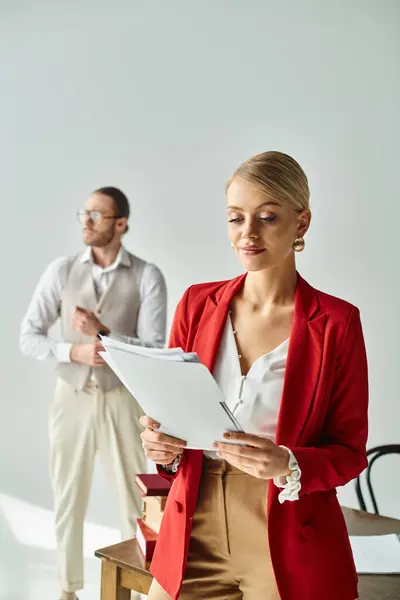 Focus on alluring woman looking at paperwork with her blurred boyfriend on backdrop, work affair — Stock Photo