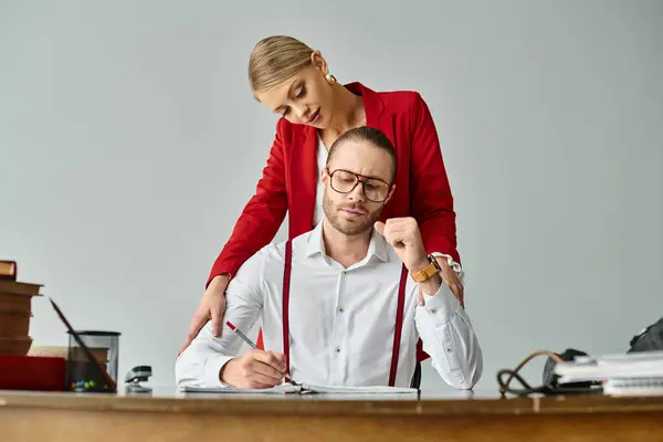 Joyous blonde woman in vibrant jacket hugging lovingly her hard working bearded boss, work affair — Stock Photo