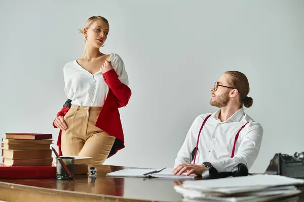 Good looking bearded man and his sexy secretary in red jacket looking lovingly at each other — Stock Photo