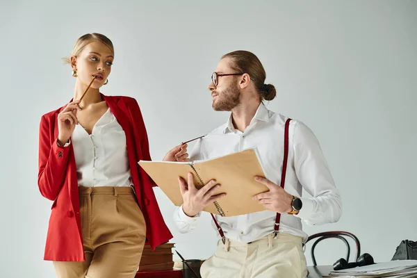 Elegant hot couple in stylish attires with accessories looking lovingly at each other in office — Stock Photo