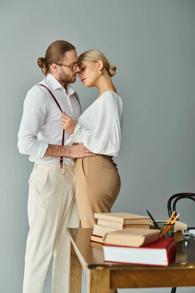 Good looking loving couple with stylish attires kissing alluringly while in office, work affair — Stock Photo
