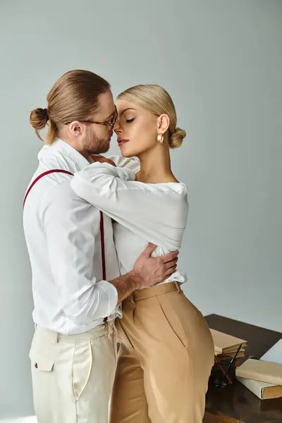 Attraktives junges Paar in modischer Kleidung umarmt und küsst sich im Büro, bei der Arbeit — Stockfoto