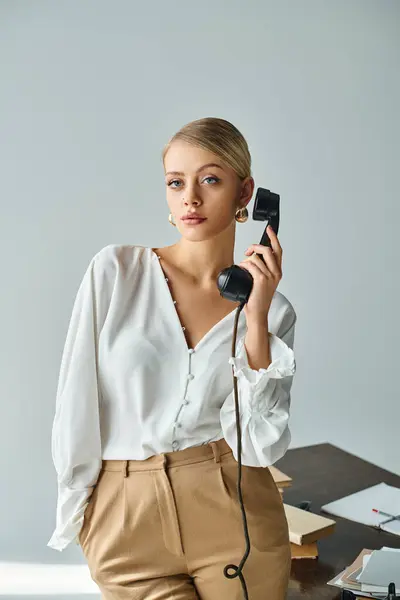 Attraktive junge Frau mit blonden gesammelten Haaren spricht per Retro-Telefon und blickt in die Kamera — Stockfoto