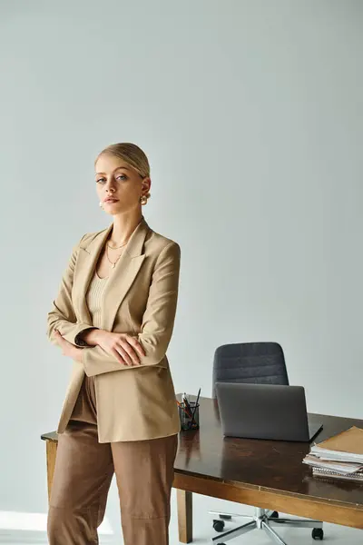 Good looking woman with blonde hair in elegant suit with arms crossed on chest looking at camera — Stock Photo
