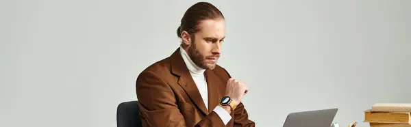 Concentrated man with beard and wristwatch in elegant jacket working on his laptop at office — Stock Photo