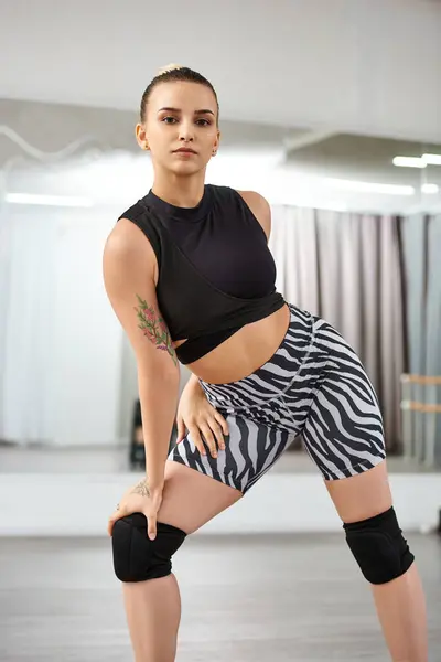 Уравновешенная женщина в верхней и зебровых шортах изящно двигает конечностями и туловищем в хореографическом танце — стоковое фото