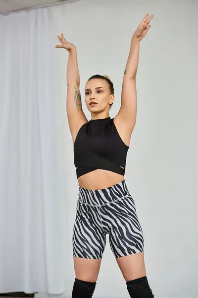 Uma dançarina graciosa em uma roupa marcante executa uma coreografia dinâmica, enquanto levanta as mãos — Fotografia de Stock