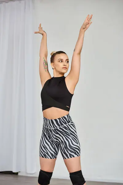 Uma mulher graciosa em uma roupa marcante executa uma coreografia dinâmica, enquanto levanta as mãos — Fotografia de Stock
